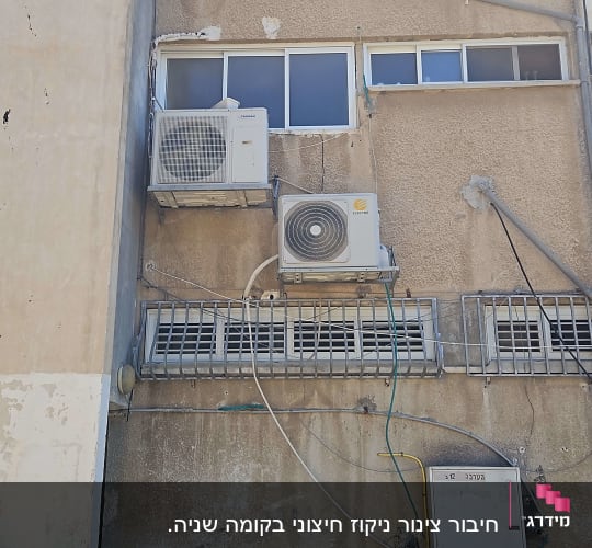 שני מזגנים מותקנים על קיר חיצוני של בניין
